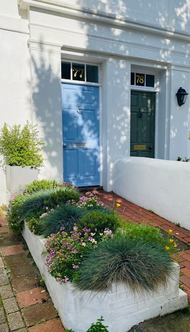 An ornate black front door with decorative stained glass panels, framed by classical white columns and detailed cornicing, leads to a Victorian-style residential entrance. The entrance is accessed via